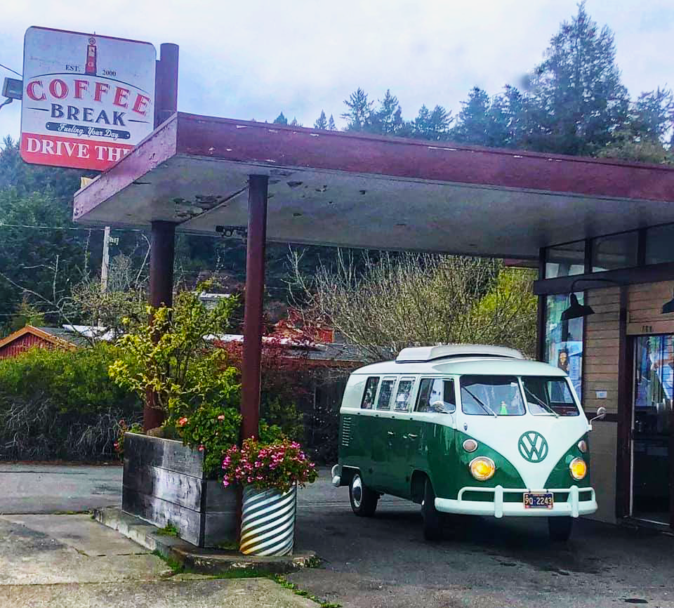 A classic VW van sits waiting for their coffee at the drive through.